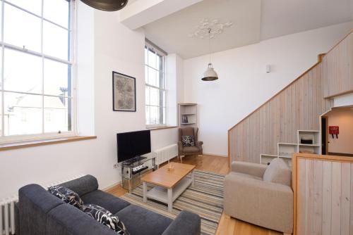 a living room with a couch and a tv at Destiny Scotland - Broughton St Lofts in Edinburgh