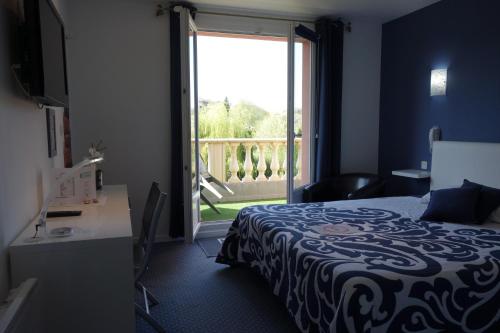 a hotel room with a bed and a door to a balcony at Côté Jardin in Commercy