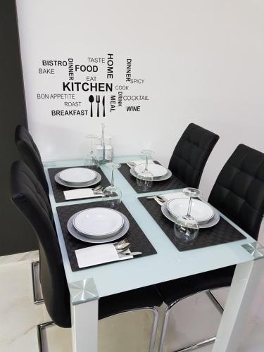 a table with black chairs and white plates on it at Route 77 in Thessaloniki