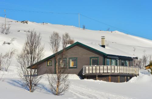 a house in the snow in front of a mountain at Rivdnji Holiday Home Smørfjord in Russenes