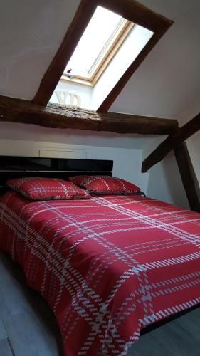 - un lit rouge dans une chambre avec fenêtre dans l'établissement Duplex Notre Dame, à Paris