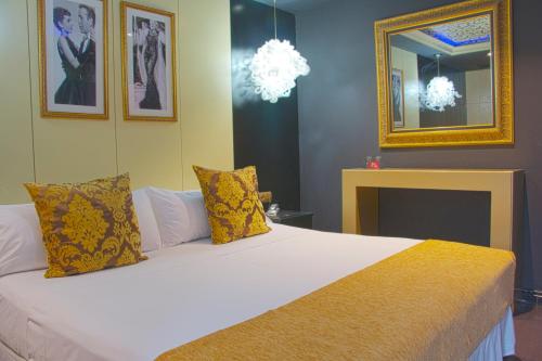 a bedroom with a large white bed with yellow pillows at Hotel Años 50 in Torremolinos