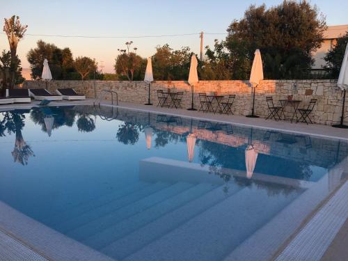 a swimming pool with chairs and a wall at Carone Suite-Charme&Pool by Bluette in Polignano a Mare