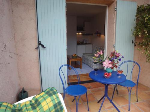 - une table bleue avec des chaises et des fleurs sur la terrasse dans l'établissement Le Mas des Gardettes, à Saint-Paul-de-Vence