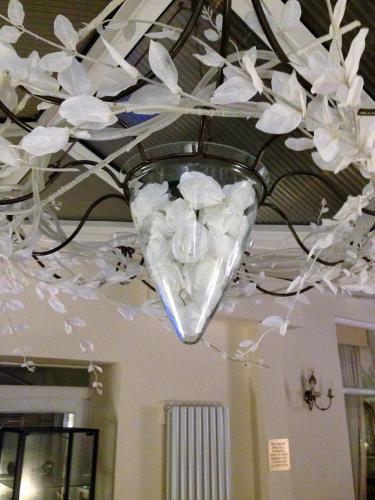 a chandelier with white flowers hanging from a ceiling at The Old Coach House in Blackpool