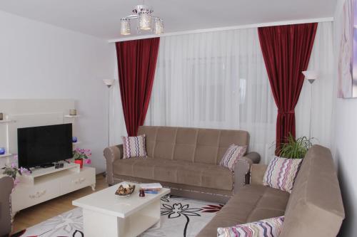 a living room with a couch and a tv at Rumi Apartments in Sarajevo