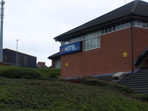 a building with a sign on the side of it at 247Hotel in Oldham