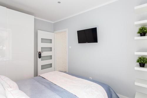 グダニスクにあるFahrenheit Centrum Ogarnaのベッドルーム1室(ベッド1台、壁掛けテレビ付)
