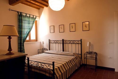 リオトルトにあるAgriturismo Poggio Agli Uliviのベッドルーム1室(ベッド1台、ランプ、窓付)