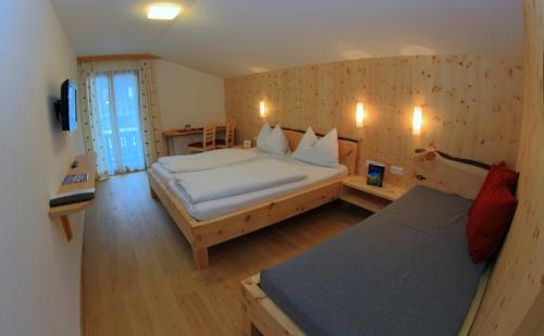 a hotel room with two beds and a television at Bio-Pension Bliem in Altenmarkt im Pongau