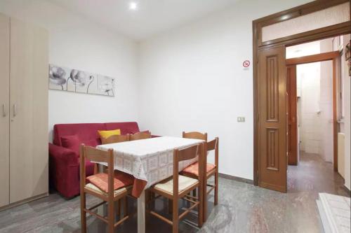 ローマにあるVia Palestro 56 Apartmentのダイニングルーム(テーブル、赤いソファ付)