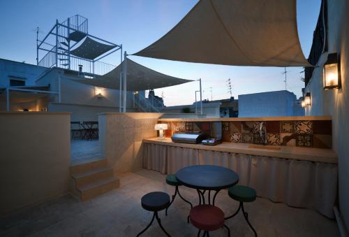 a patio with a table and stools on a balcony at Casa Galateo 20 in Gallipoli
