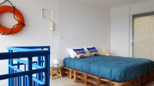 a bedroom with a blue bed and a basketball on the wall at Farol da Vila in Vila Franca do Campo