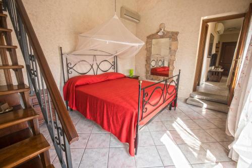 a bedroom with a bed with a red blanket and a mirror at Appartamenti Bellavista - HelloElba in Portoferraio
