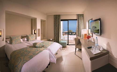 a bedroom with a bed and a desk and a window at Club Palm Azur Families and Couples in Midoun