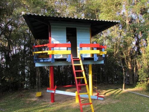 a tree house with a ladder in a yard at Laggus Residencial Náutico in Ferraria