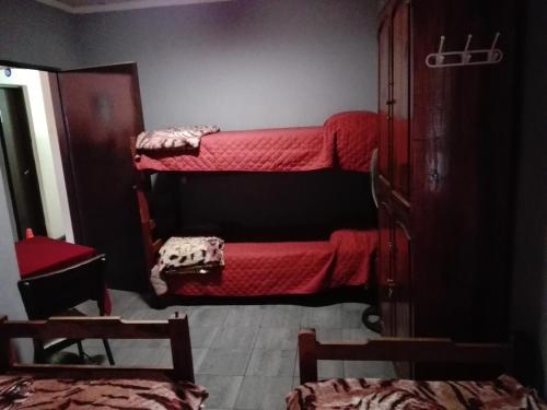 a room with two bunk beds with red blankets at Hostal Namaste in Salta