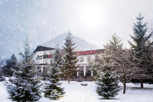 a building with trees in front of it in the snow at Borová Sihoť ATC and penzion in Liptovský Hrádok