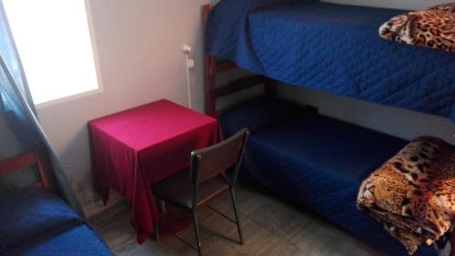 a room with a table and a chair and a bunk bed at Hostal Namaste in Salta