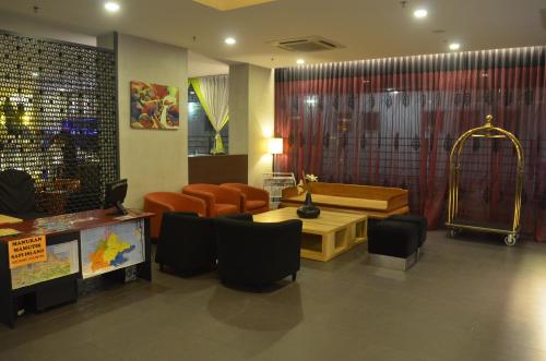 a lobby with a waiting room with chairs and a table at Cozy Living Sky Apartment in Kota Kinabalu