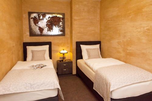 two twin beds in a room with a picture on the wall at Penzion BERG in Bratislava