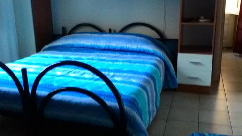 a bed with a blue blanket on it in a room at Bed And Breakfast Priscilla in Regalbuto