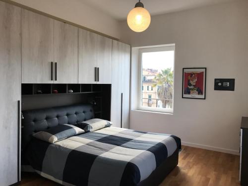 sypialnia z czarno-białym łóżkiem i oknem w obiekcie Stella Del Mare w mieście La Spezia