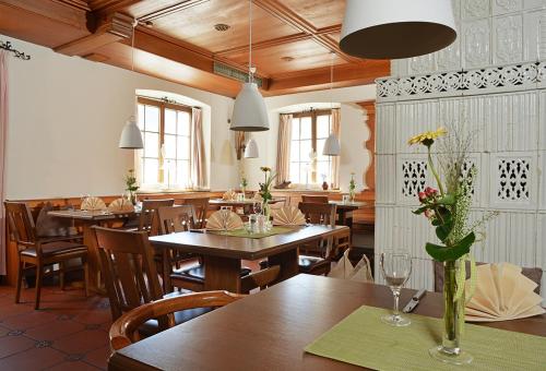 un restaurante con mesas de madera y sillas con flores. en Hotel Restaurant Klosterhof en Gutenzell-Hürbel