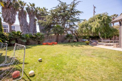 a yard with a lawn chair, tennis ball, and lawn mower at PodShare Venice in Los Angeles