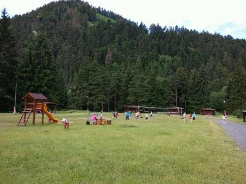 a group of people in a field with a playground at Borová Sihoť ATC and penzion in Liptovský Hrádok