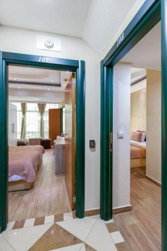 a room with two beds and a door to a bedroom at Hotel Green Center Gili in Gostivar