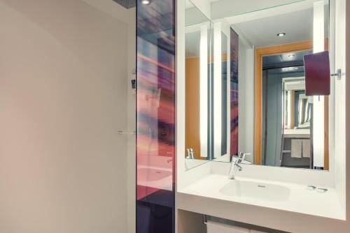 a bathroom with a sink and a mirror at Mercure Paris Boulogne in Boulogne-Billancourt