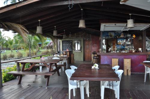 um restaurante com mesas e cadeiras de madeira e um bar em Frangipani Apartment em Christ Church