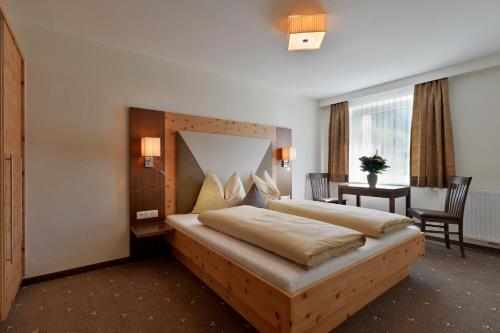 a hotel room with a bed and a desk and a table at Berggasthaus Steinerkogl in Brandberg