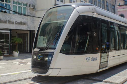 a white tram driving down a city street at Hotel Meu Cantinho (Adults Only) in Rio de Janeiro