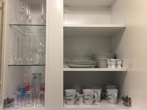 a white cabinet with dishes and cups and plates at Sunny VIE in Vienna