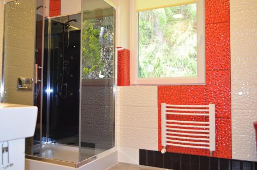 uma casa de banho com um chuveiro e uma janela em Luzik Krynica em Krynica-Zdrój