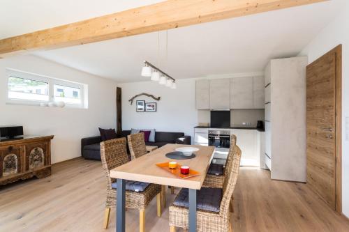 a kitchen and living room with a wooden table and chairs at Haus am Stein in Oetz