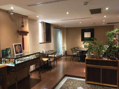 un soggiorno con tavoli, sedie e un bar di Fu Chang Hotel a Taipei