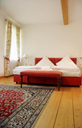 a bedroom with a bed with a red foot board at Hotel Restaurant Sengscheider Hof in Sankt Ingbert