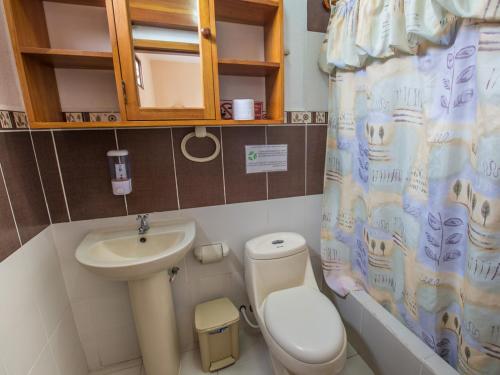 a small bathroom with a toilet and a sink at Galapagos Dreams in Puerto Ayora