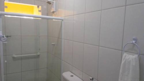 a white bathroom with a shower and a toilet at Pousada do Bosque Amargosa in Amargosa