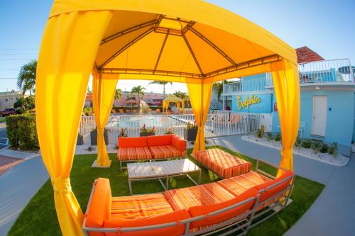 a gazebo with orange chairs and tables on a patio at St. Pete Beach Suites in St Pete Beach