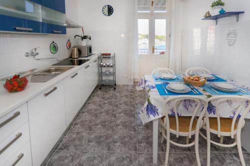 a kitchen with a table with chairs and a sink at Beach Apartment Bacvice in Split
