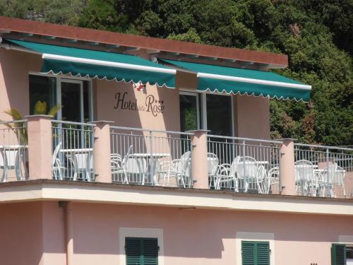 a balcony with chairs and tables on a building at Hotel Delle Rose in Bonassola