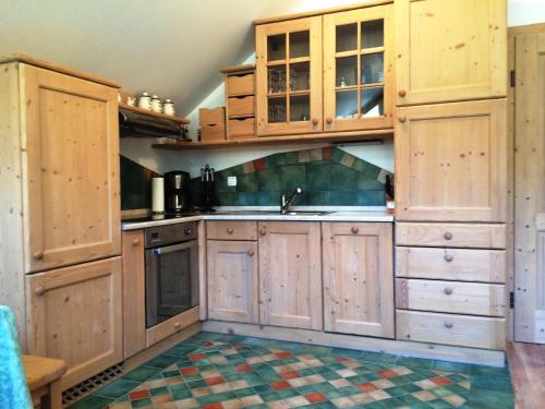 a kitchen with wooden cabinets and a sink at Apartments Pod macesnovo streho in Solčava