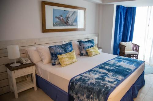 a bedroom with a large bed with blue pillows at Hotel Marqués del Mar in Mar del Plata