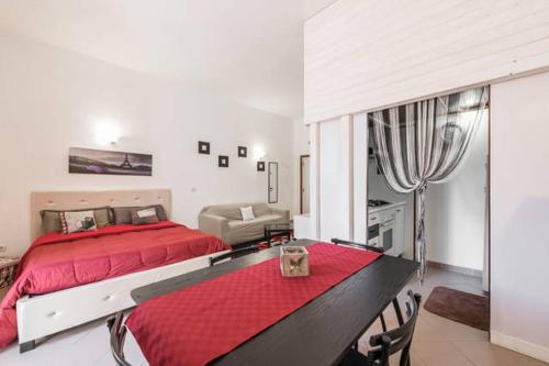 Un dormitorio con una gran cama roja y una mesa en Little Home, en Trani