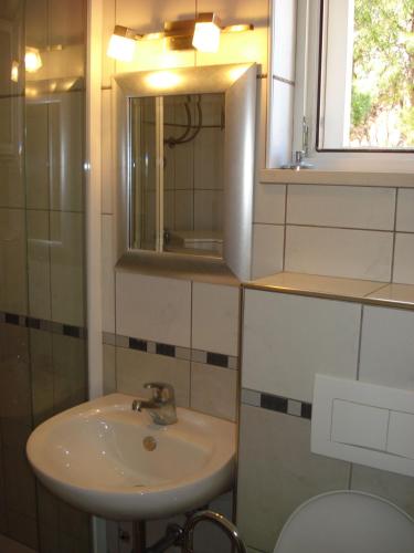 a bathroom with a sink and a mirror and a toilet at Sea Star Apartment in Sutivan