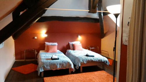 B&B Le Courtil في Dohan: غرفة نوم مع سريرين بطابقين مع جدران برتقالية